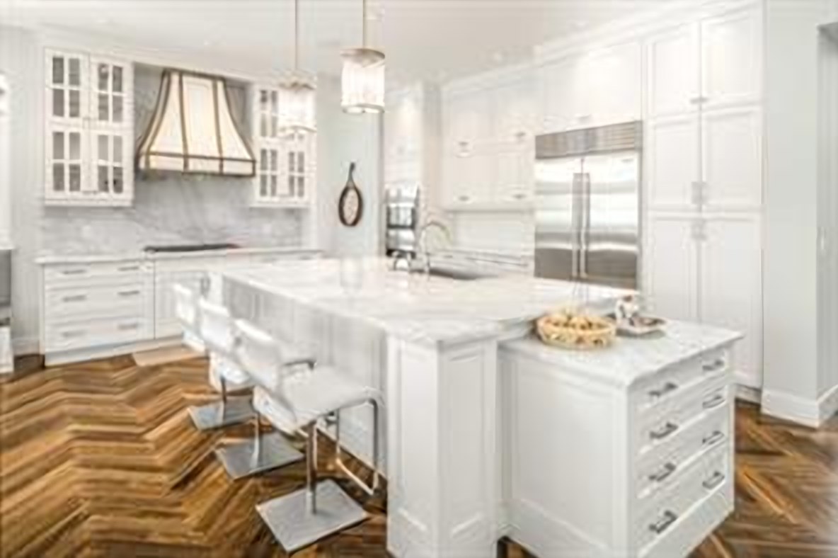 White chef&rsquo;s kitchen with an oversized marble island, Sub-Zero and Wolf