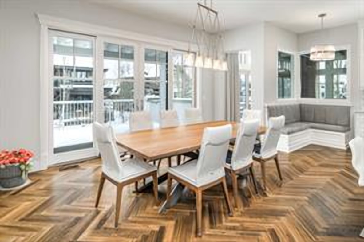 Dining room wrapped in windows, over herringbone hardwood