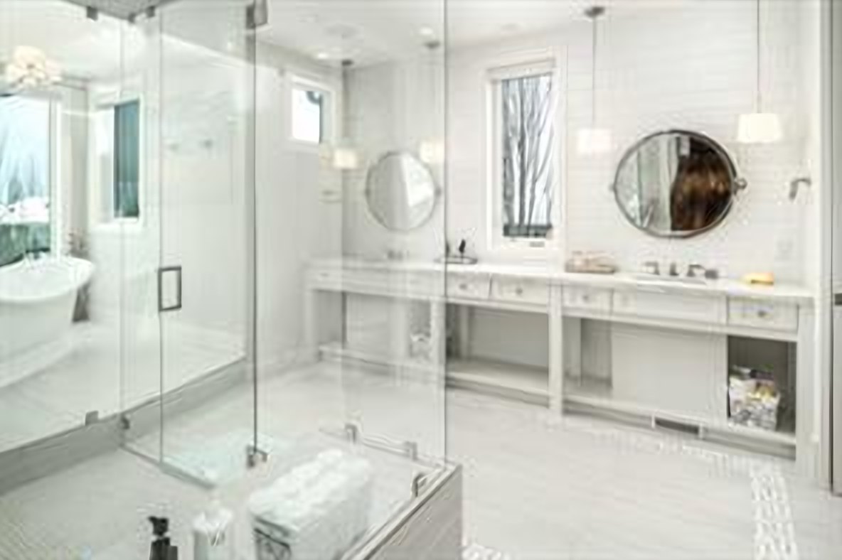 Primary ensuite with a free-standing soaker tub, glass shower and dual vanities